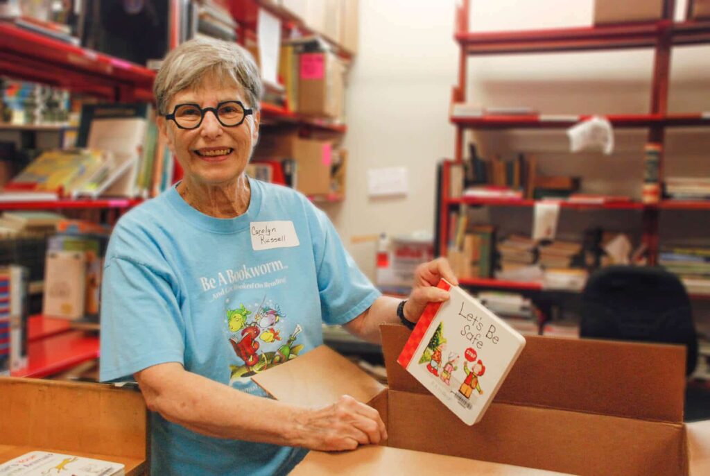 Carolyn Russell smiling as she sorts books