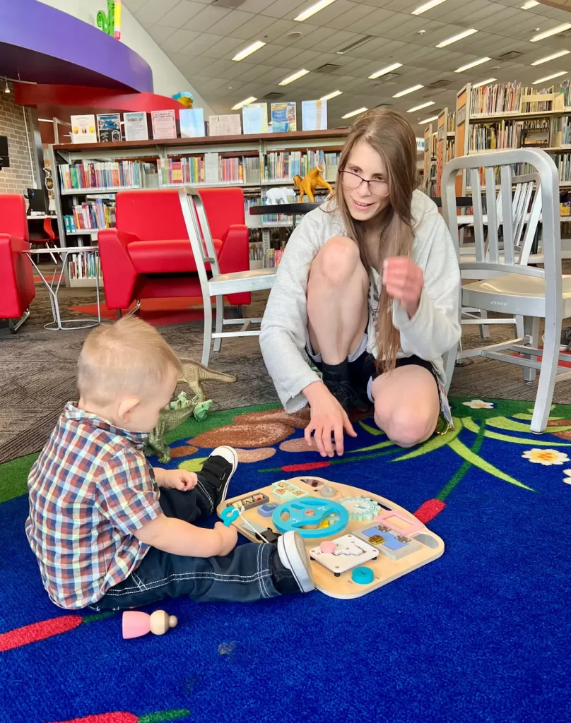Librarian check on a child having fun at the library.