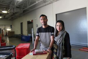 two people smiling and standing together at booksale