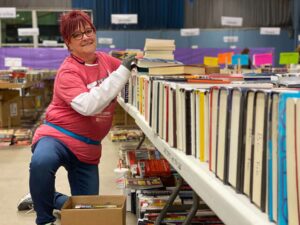 female volunteer smiling as she preps for booksale