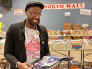 African American male smiling while reading a book
