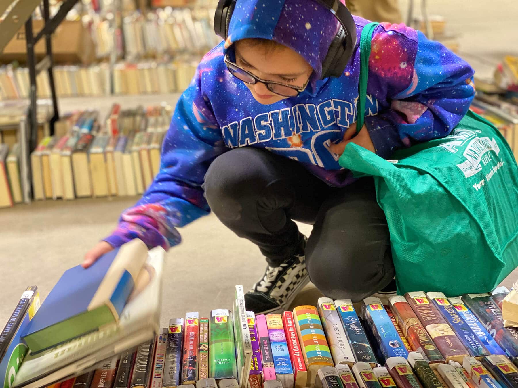 young girl browsing books at booksale