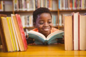 young boy happily reading a book